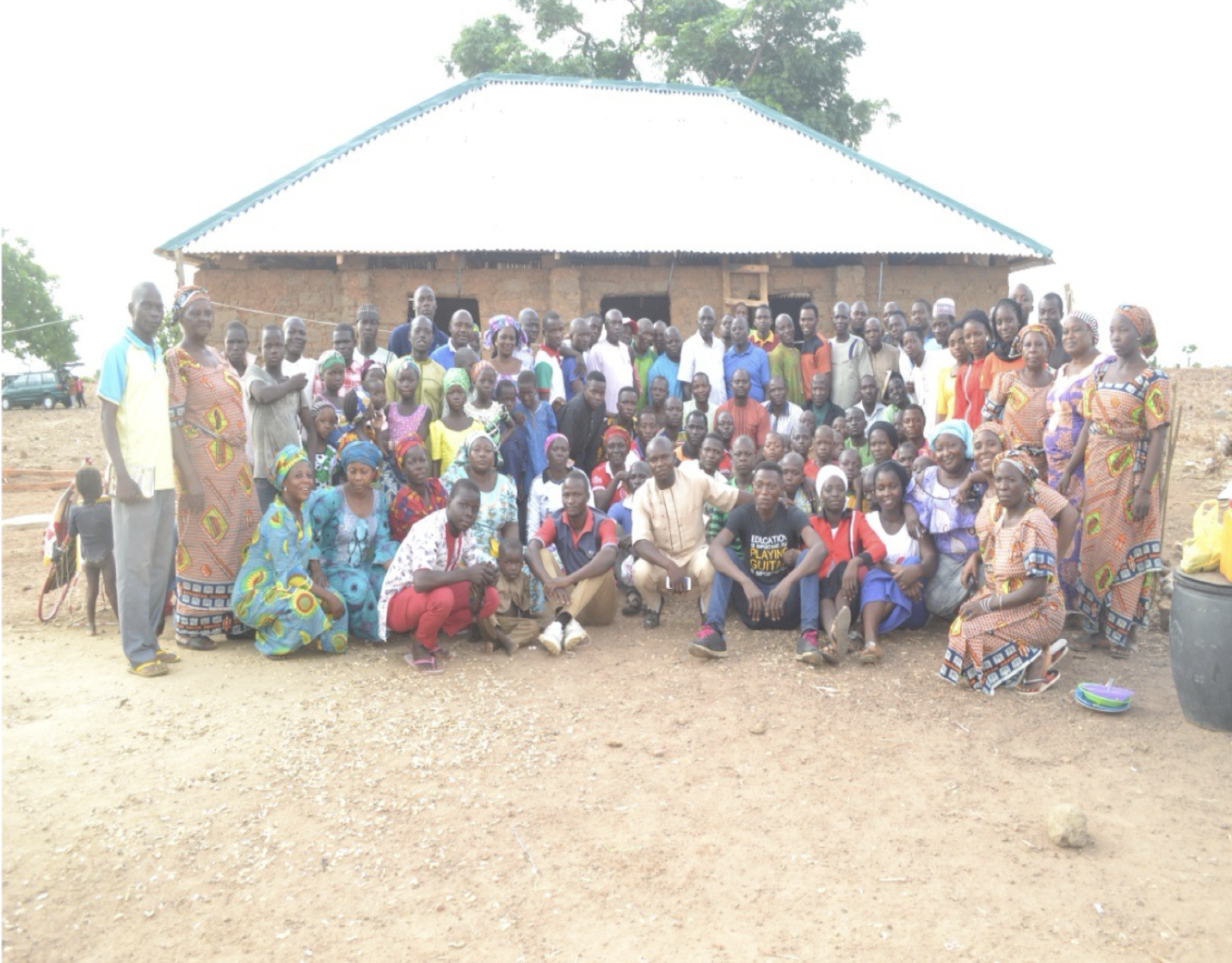 A large gathering of men, women, and children standing outside a church building on the Kangulu mission field.