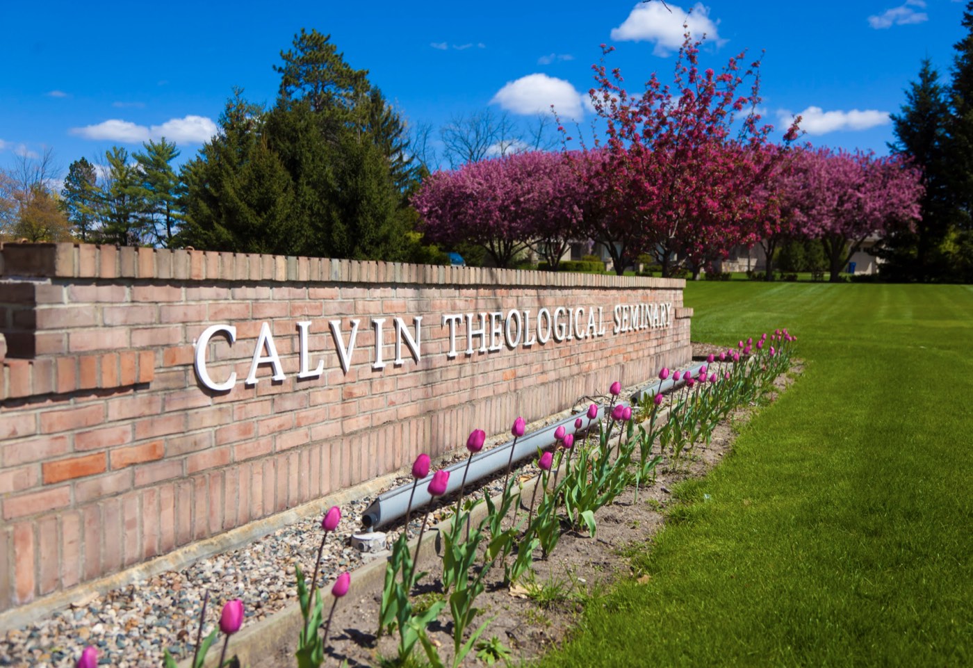 The Calvin Theological Seminary campus sign surrounded by spring flowers.