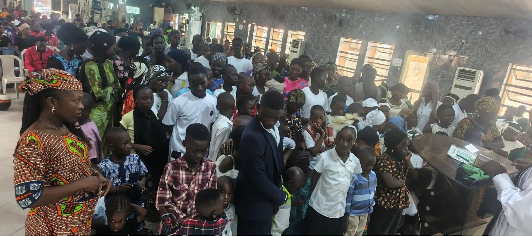 Children and adults gathered at the front of the Lagos church before demolition
