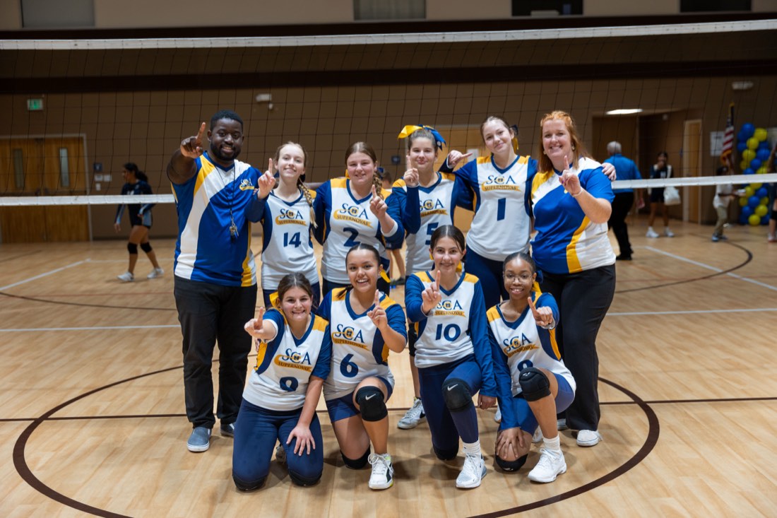Sunlight volleyball players and coaches celebrating together at homecoming.
